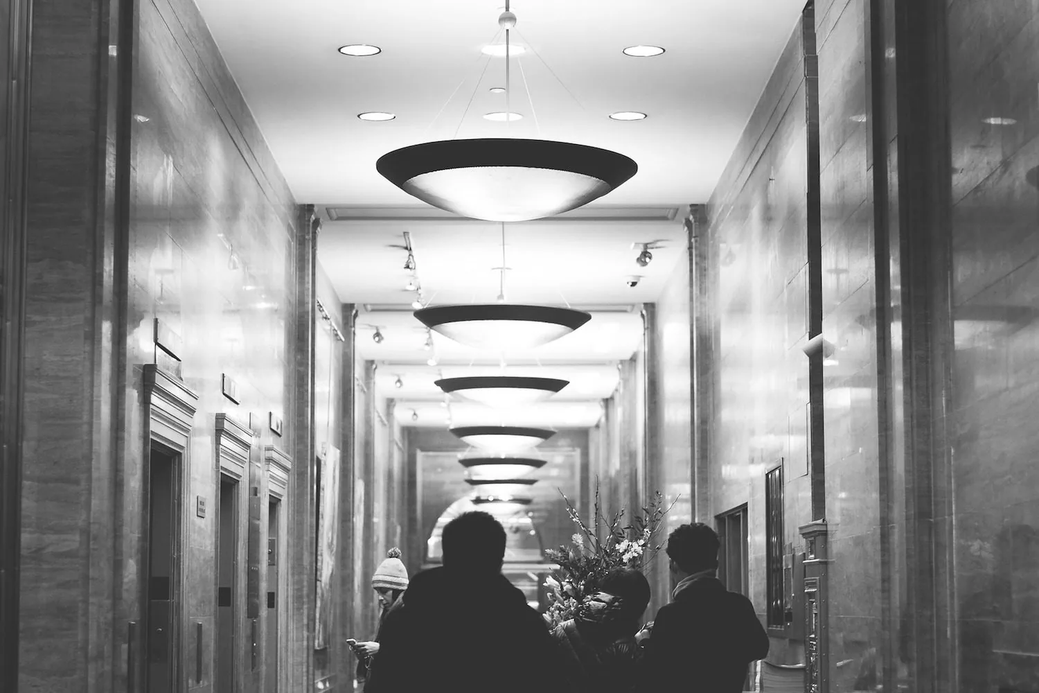 A person seen from behind in a lit corridor