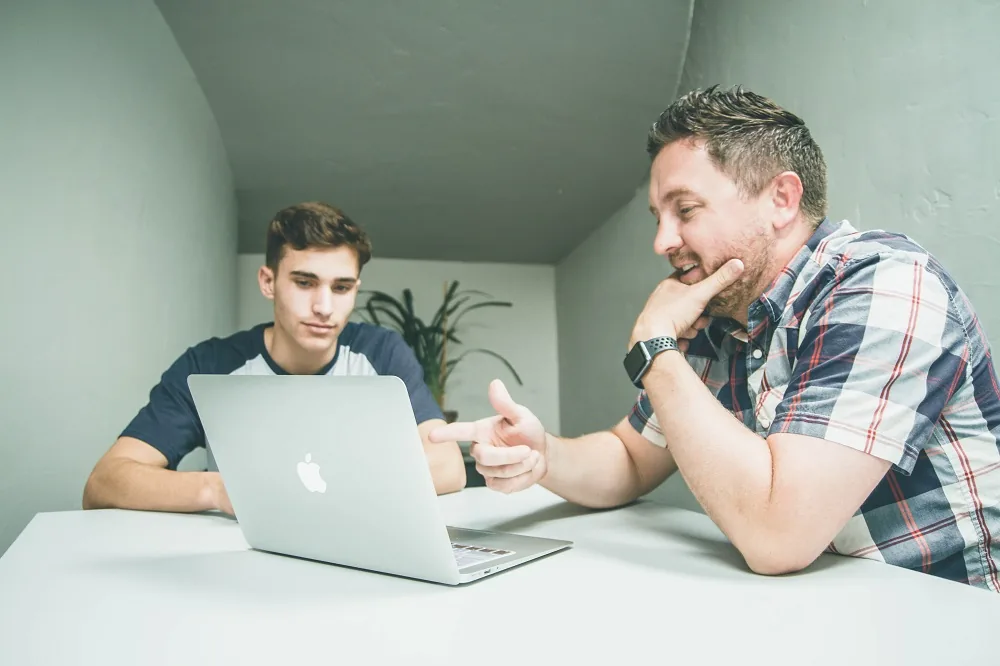 Two people looking at a laptop together