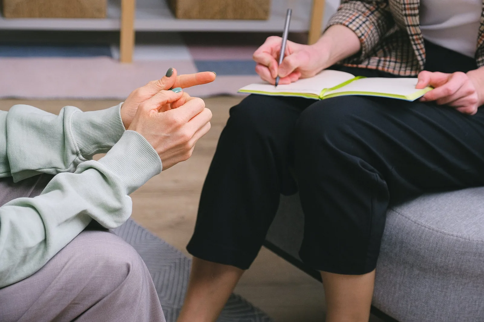 Two people talking while one writes notes