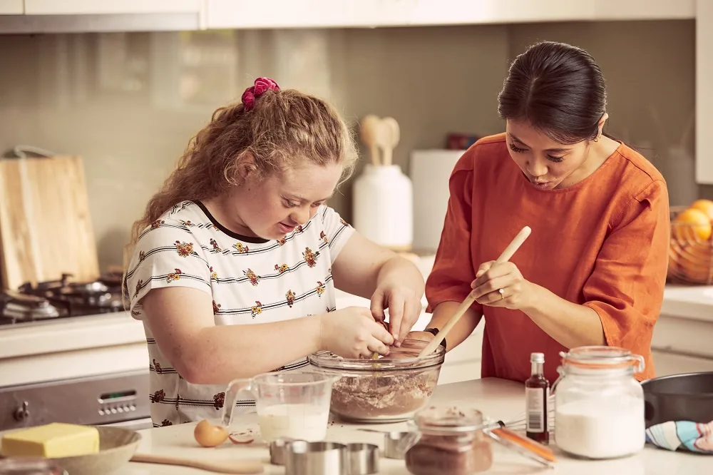 Two people preparing food together in a kitchen