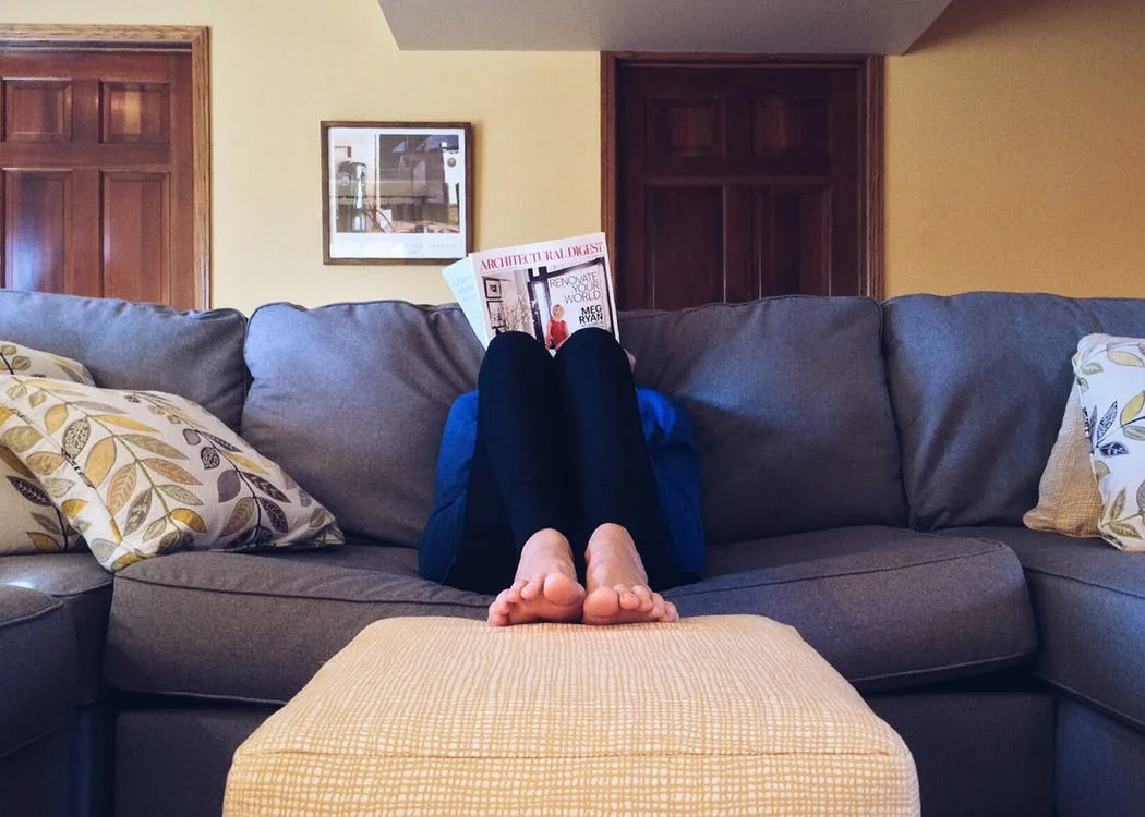 A person reading while resting on a sofa