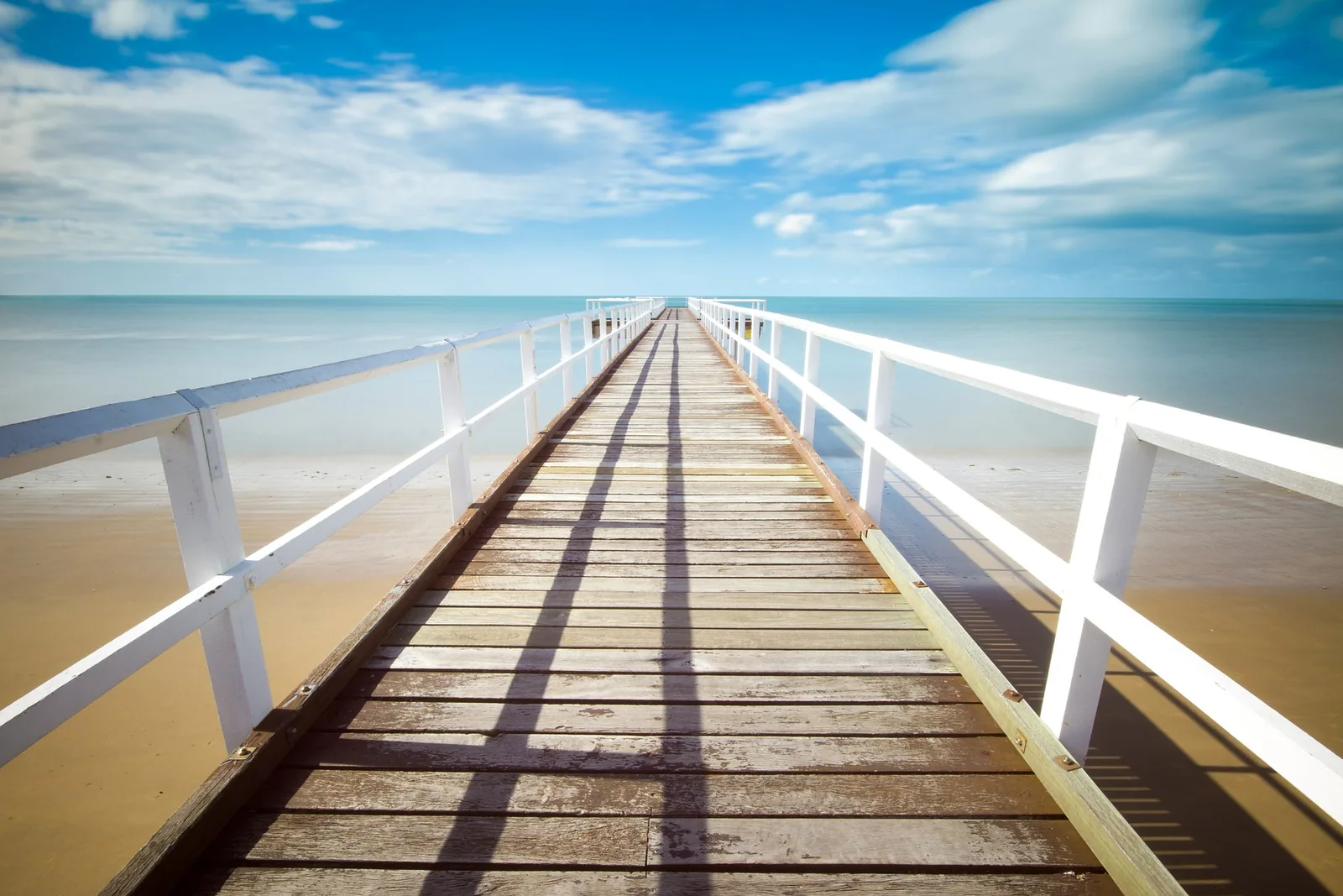 A boardwalk extending towards the sea