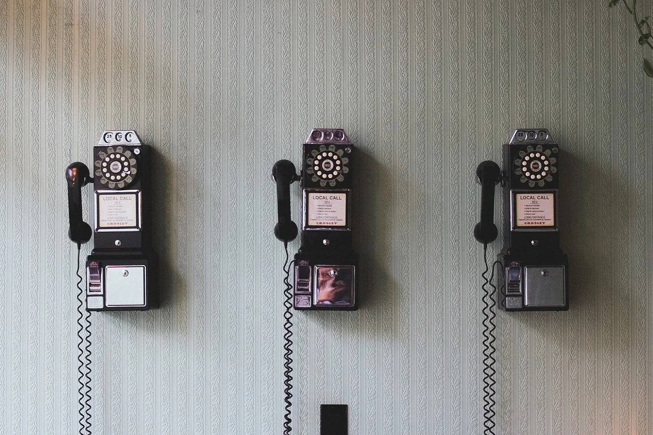 Three wall-mounted rotary telephones