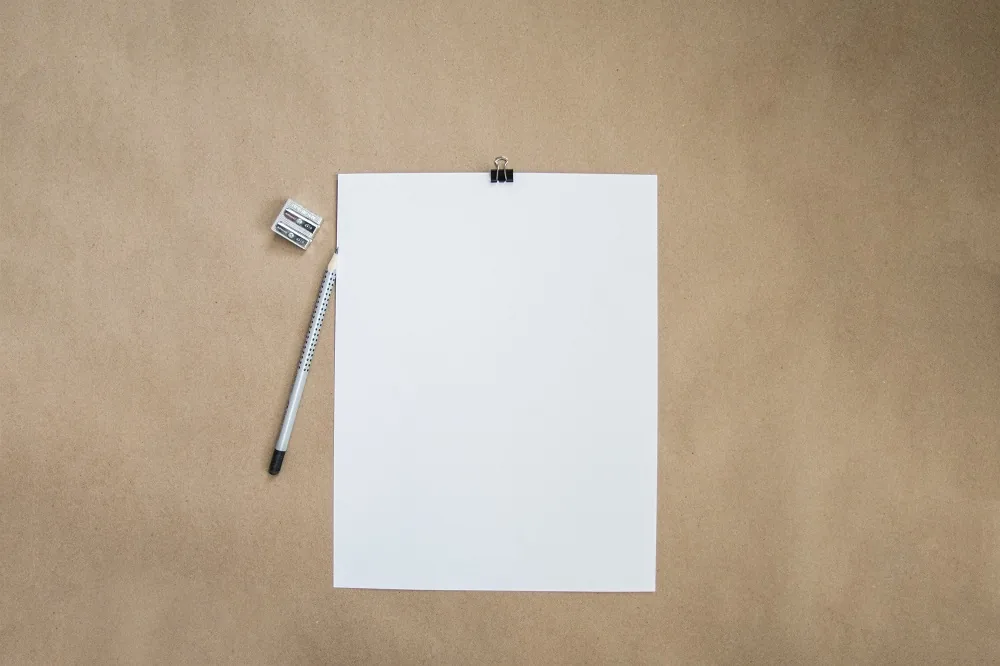 A blank notebook and pencil on a desk