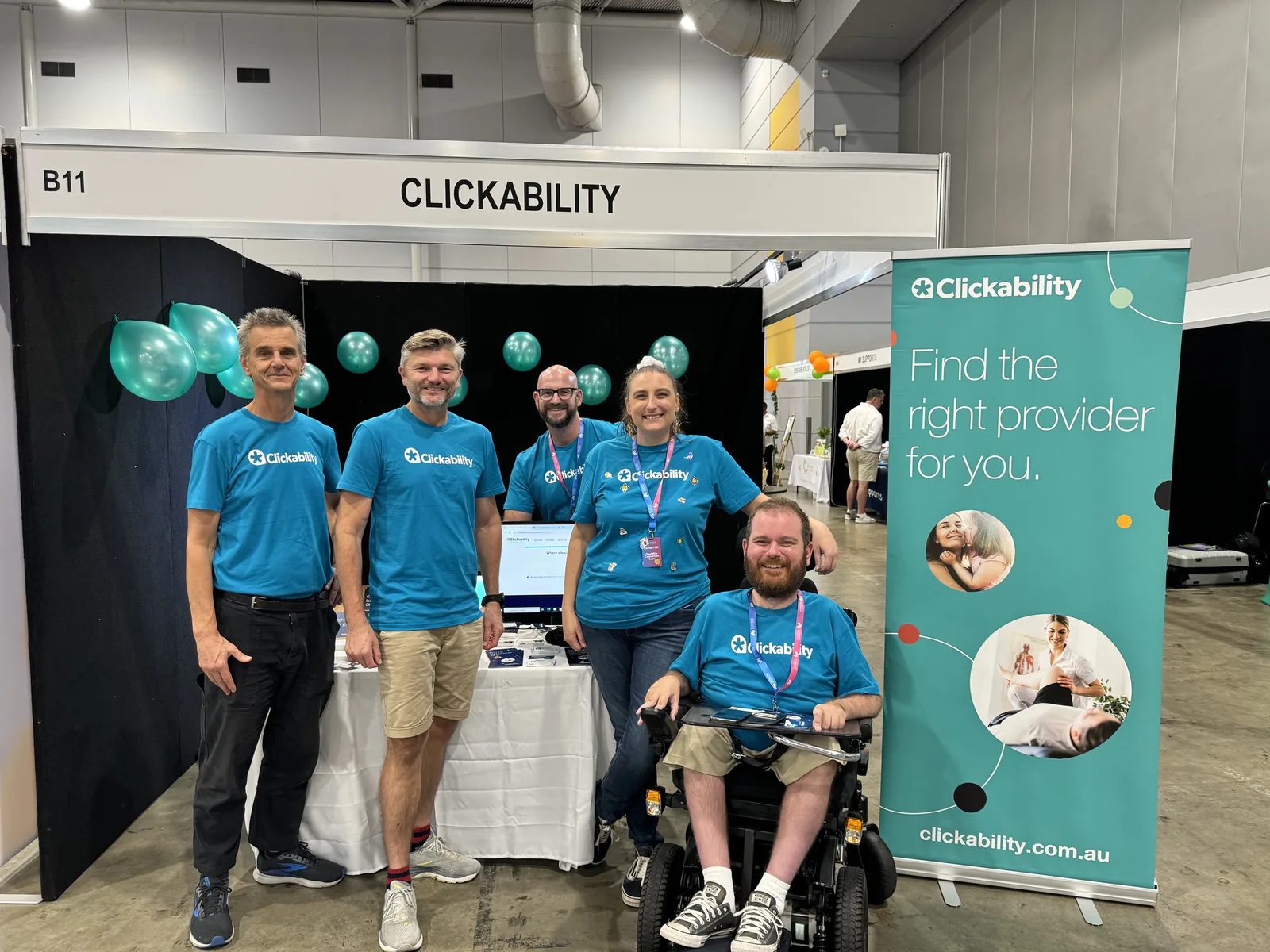 People beside a Clickability stand at a disability expo