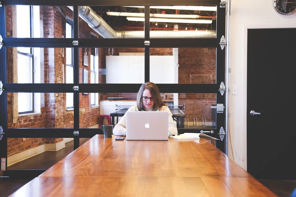 A person using a laptop at a long table