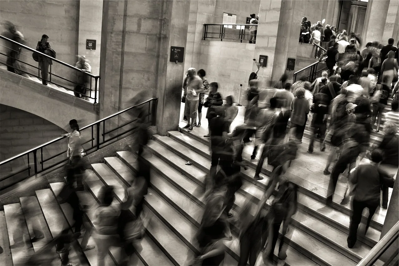 People moving through a city station in a black-and-white photograph