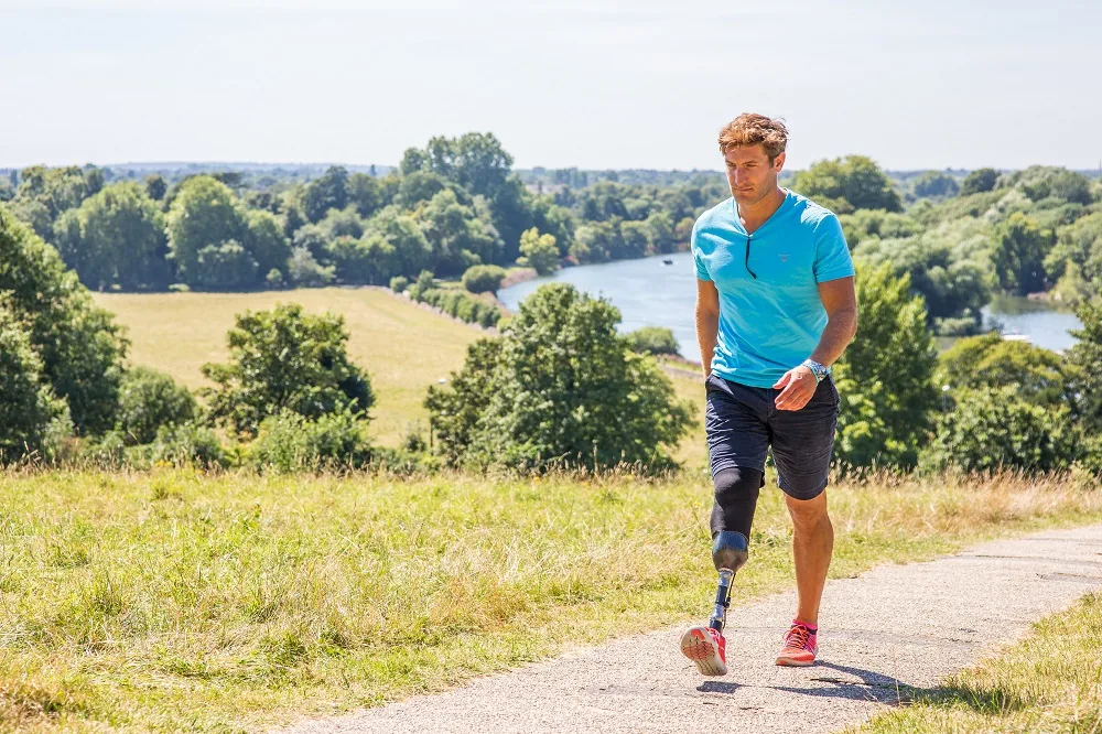 A person running outdoors using a prosthetic leg
