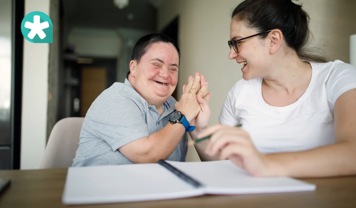 Two people smiling and gesturing at a table