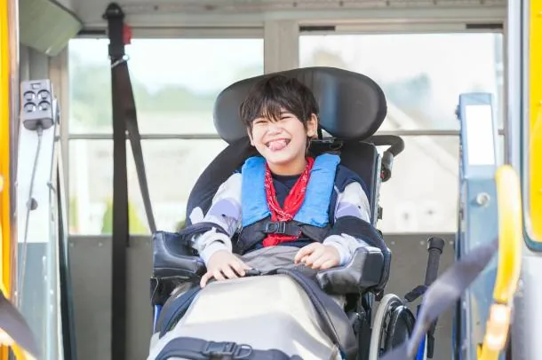 Person in a wheelchair being unloaded from a wheelchair accessible vehicle.