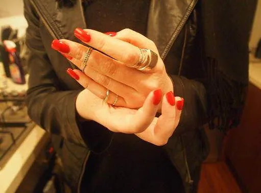 Close-up of hands with red painted fingernails