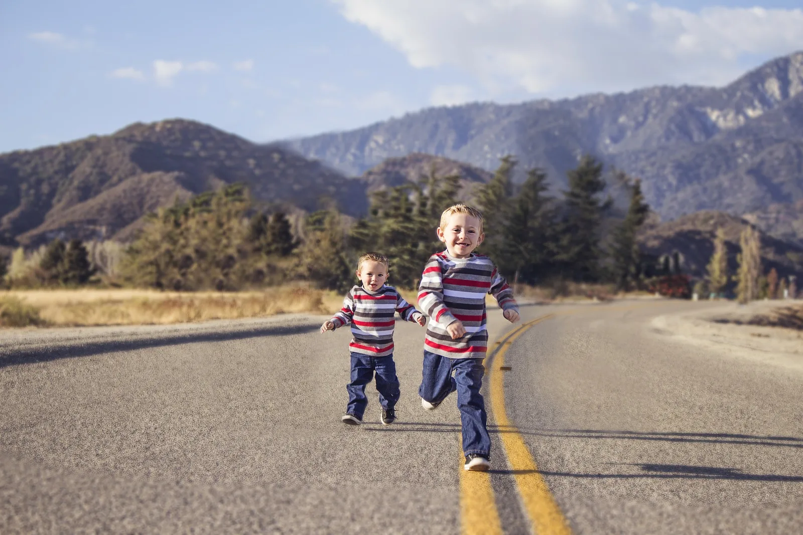 Two children walking along a quiet road