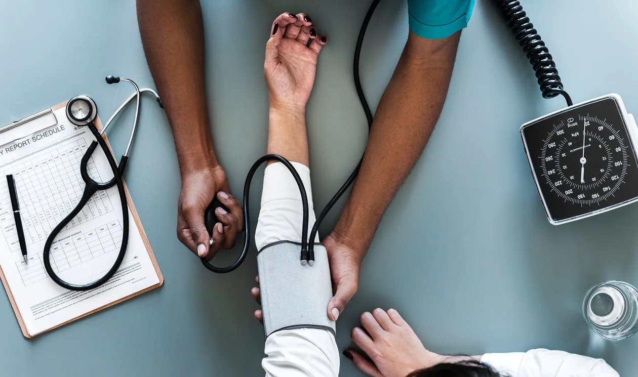 A health professional taking a seated person’s blood pressure