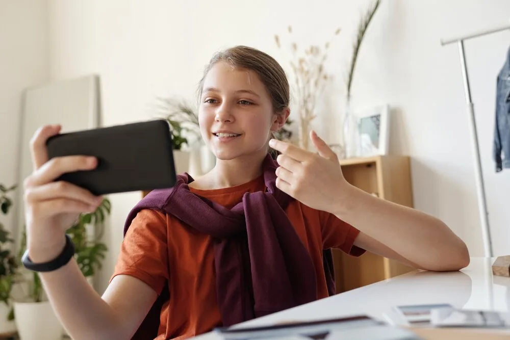 A person holding a smartphone while seated at a desk