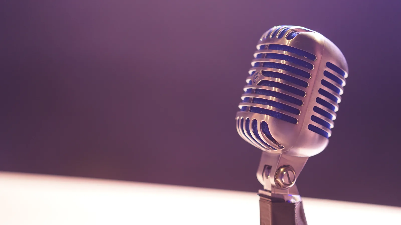 A microphone lit against a purple background