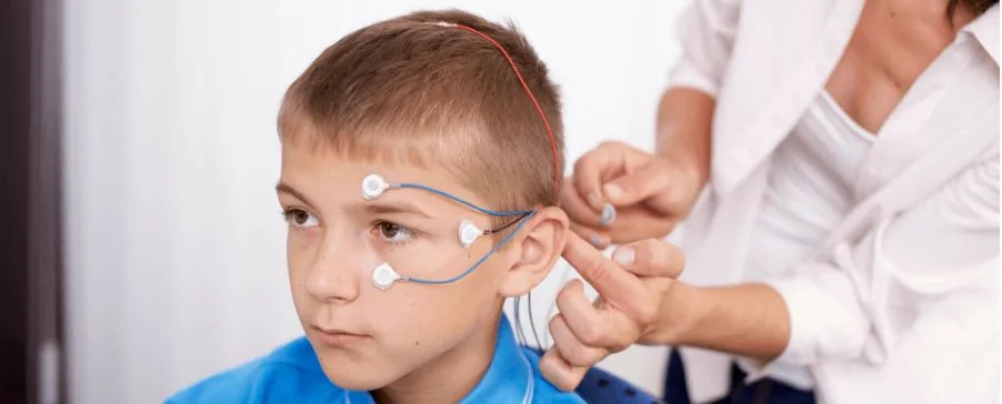 An adult fitting monitoring equipment around a child’s head
