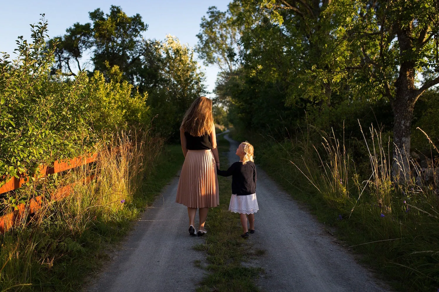 An adult and child walking along a garden path