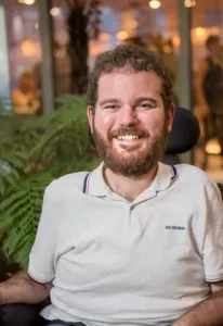 Photo of Tristram Peters, a 27 year old with a beard in a white polo shirt.