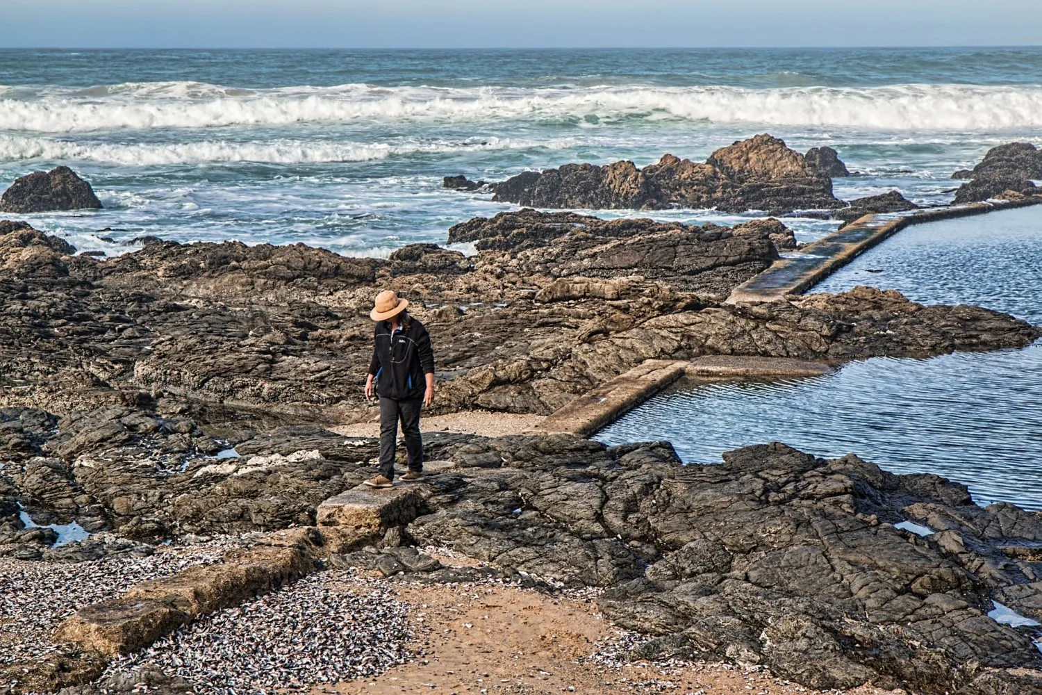 A person standing on a rocky coastline
