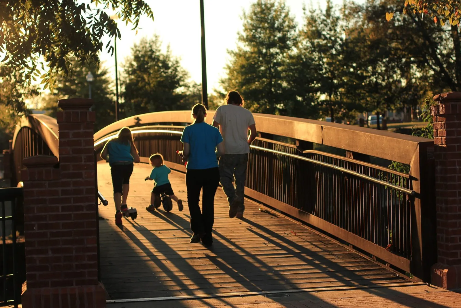 Adults and children walking along a bridge