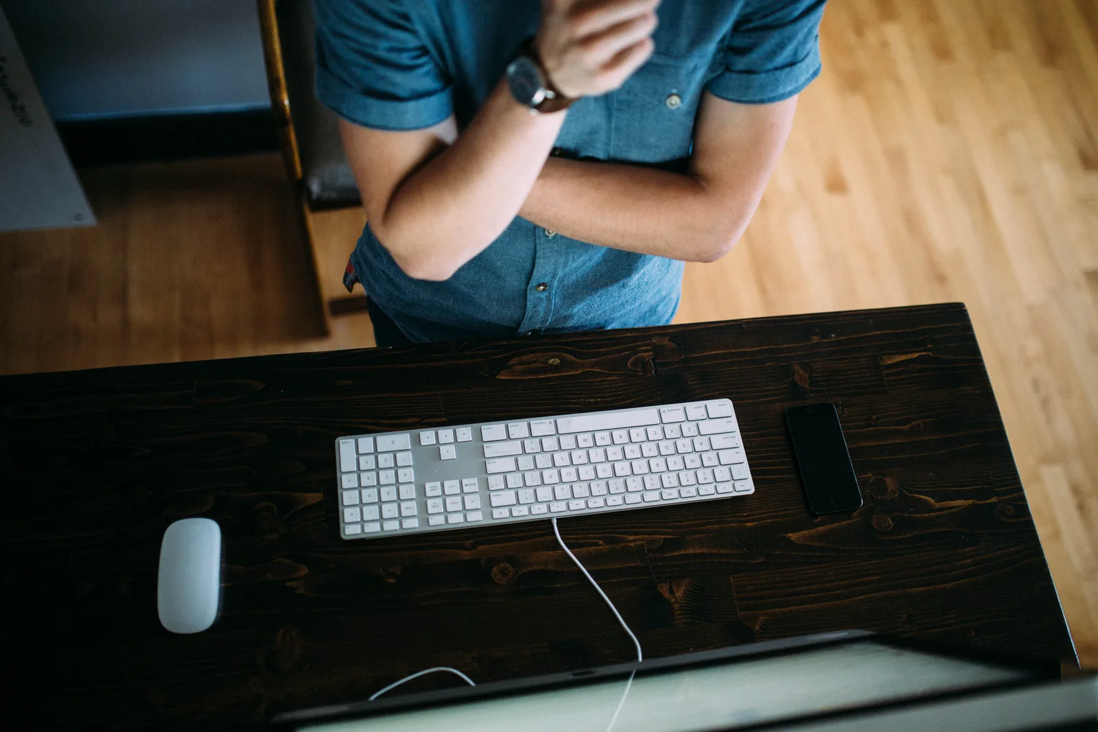 An overhead view of a person at a desk with a computer keyboard