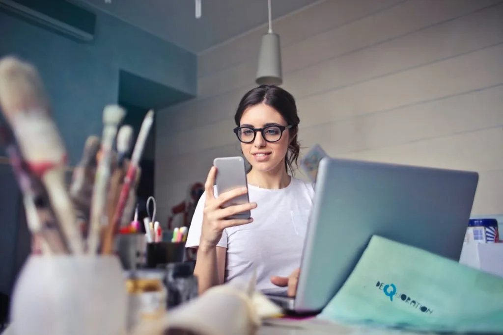 A lady looking at her phone while working.
