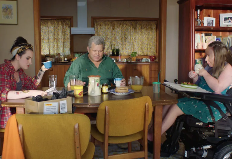 Three people sitting around a table.