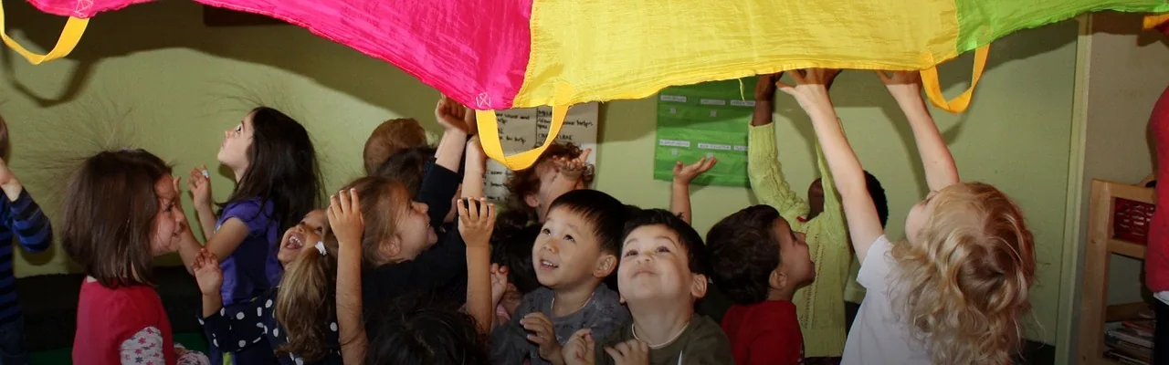 Children holding a colourful parachute in a group activity
