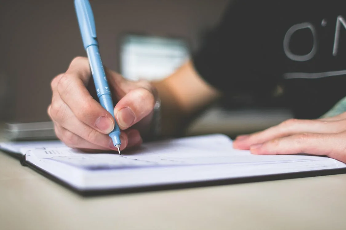A person writing on a notepad