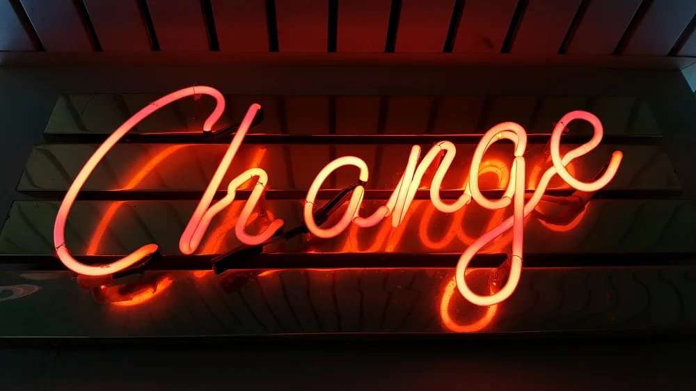 An illuminated red sign reading Change