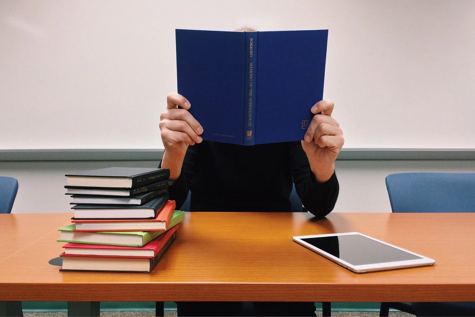 A person holding an open book in front of their face