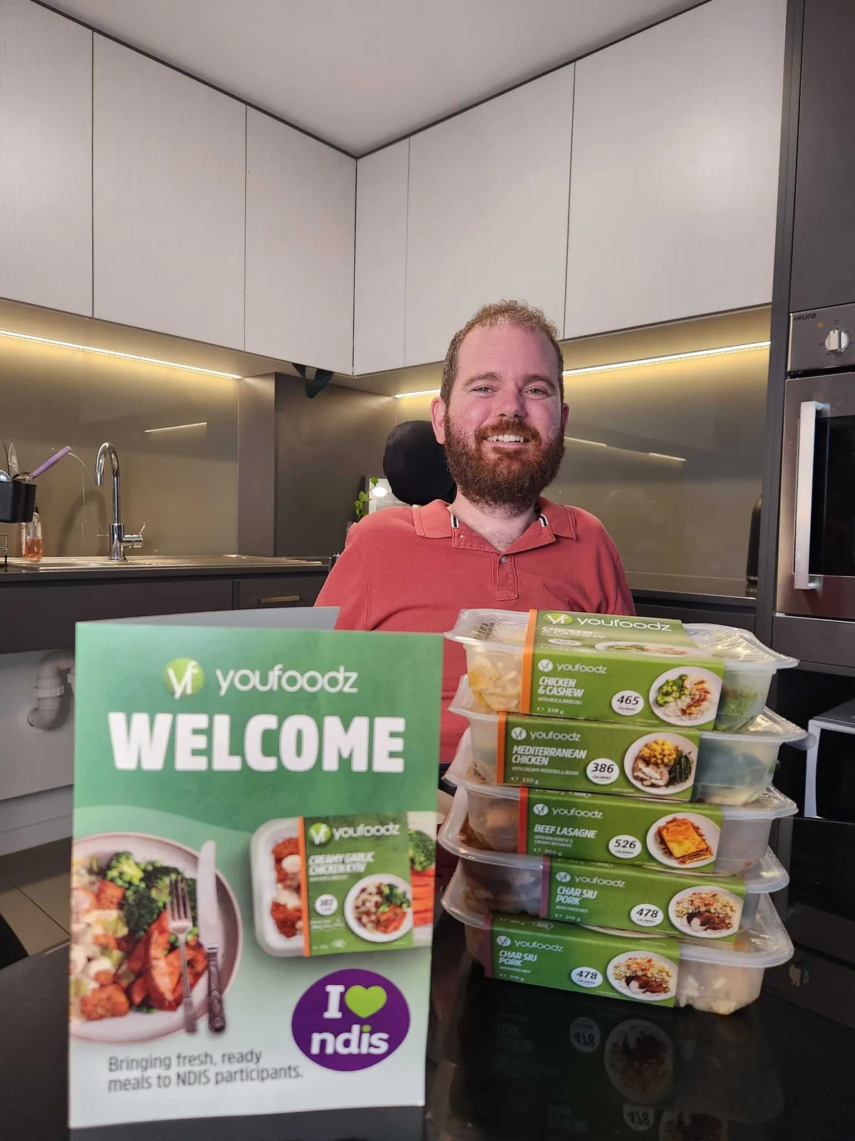 A person holding a Youfoodz box and packaged meals