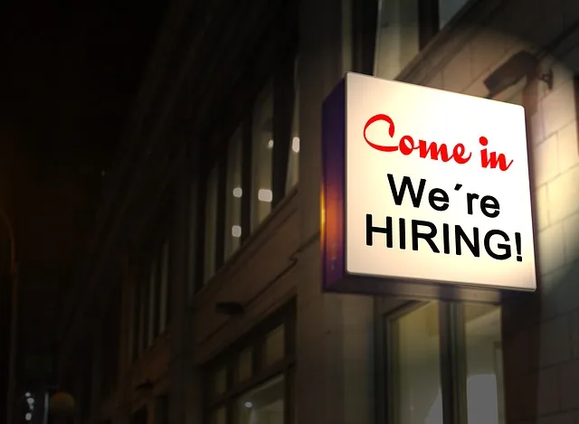 A lit sign reading Come in We’re hiring