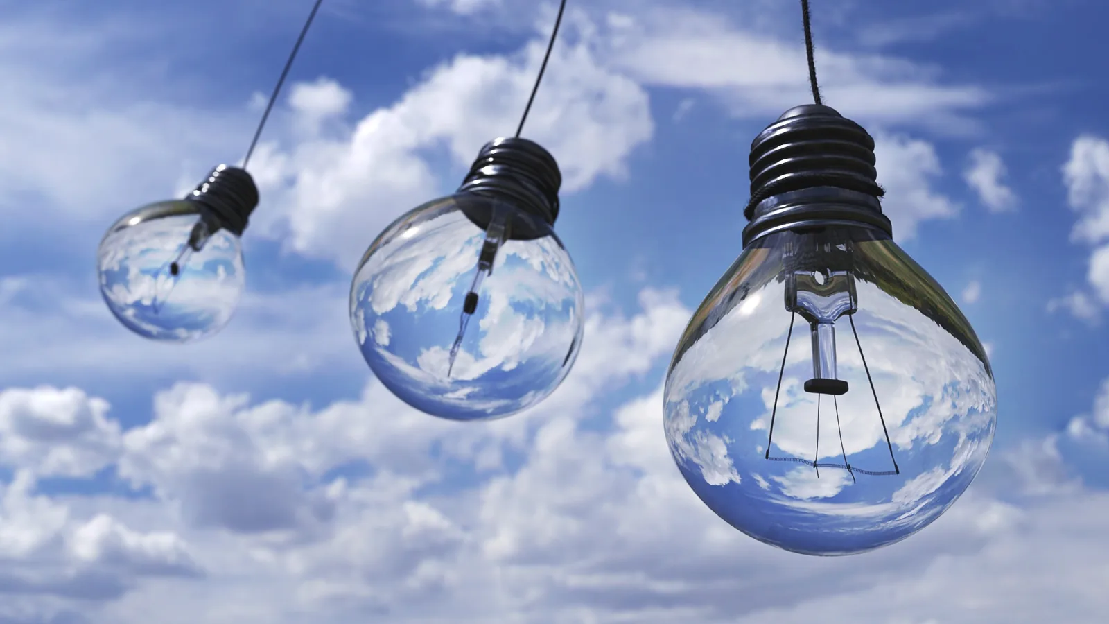 Three hanging light bulbs against a cloudy sky