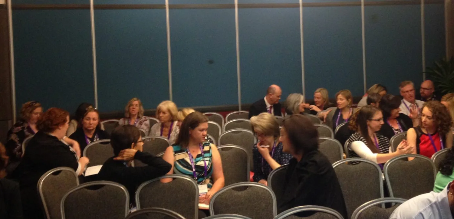 People talking in groups in a conference room