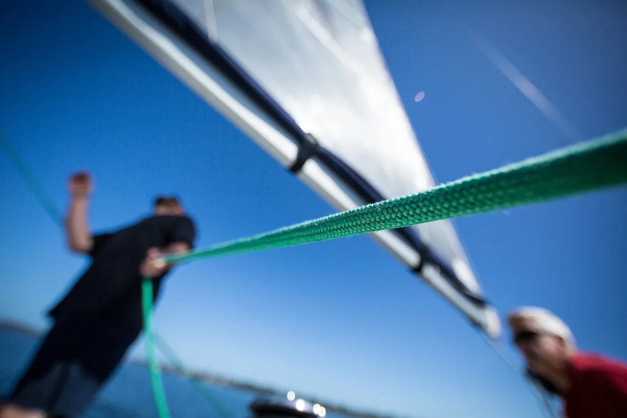 People handling a sailboat’s rigging