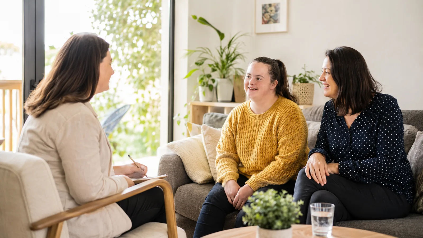 Three people talking while seated on a sofa