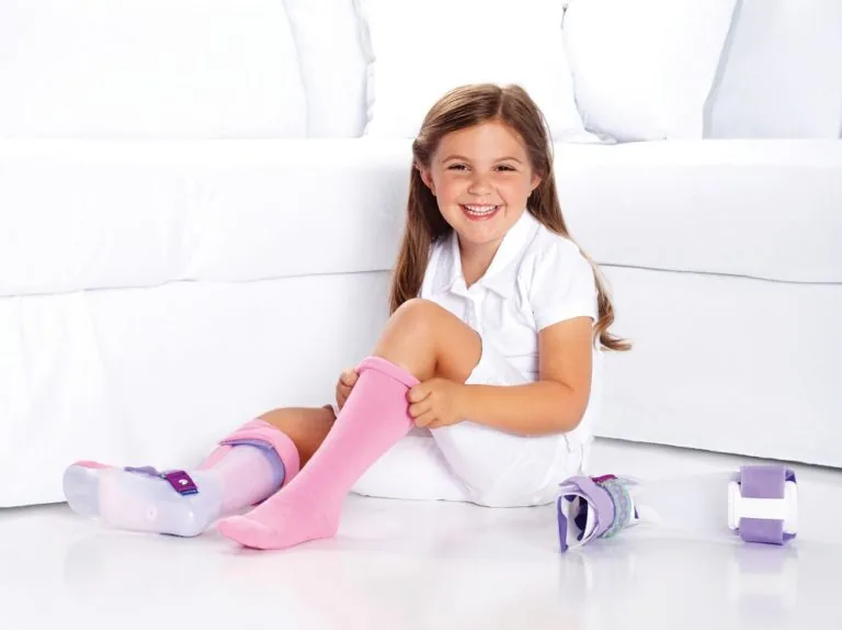 Young girl putting on orthotics.