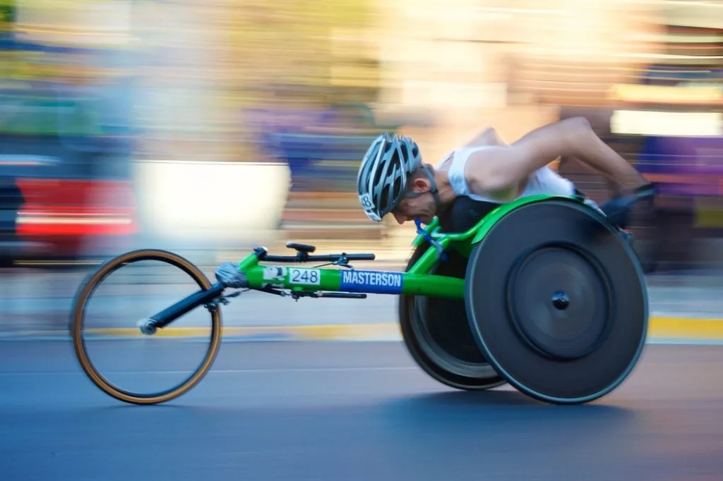 Man racing the streets in his wheelchair.