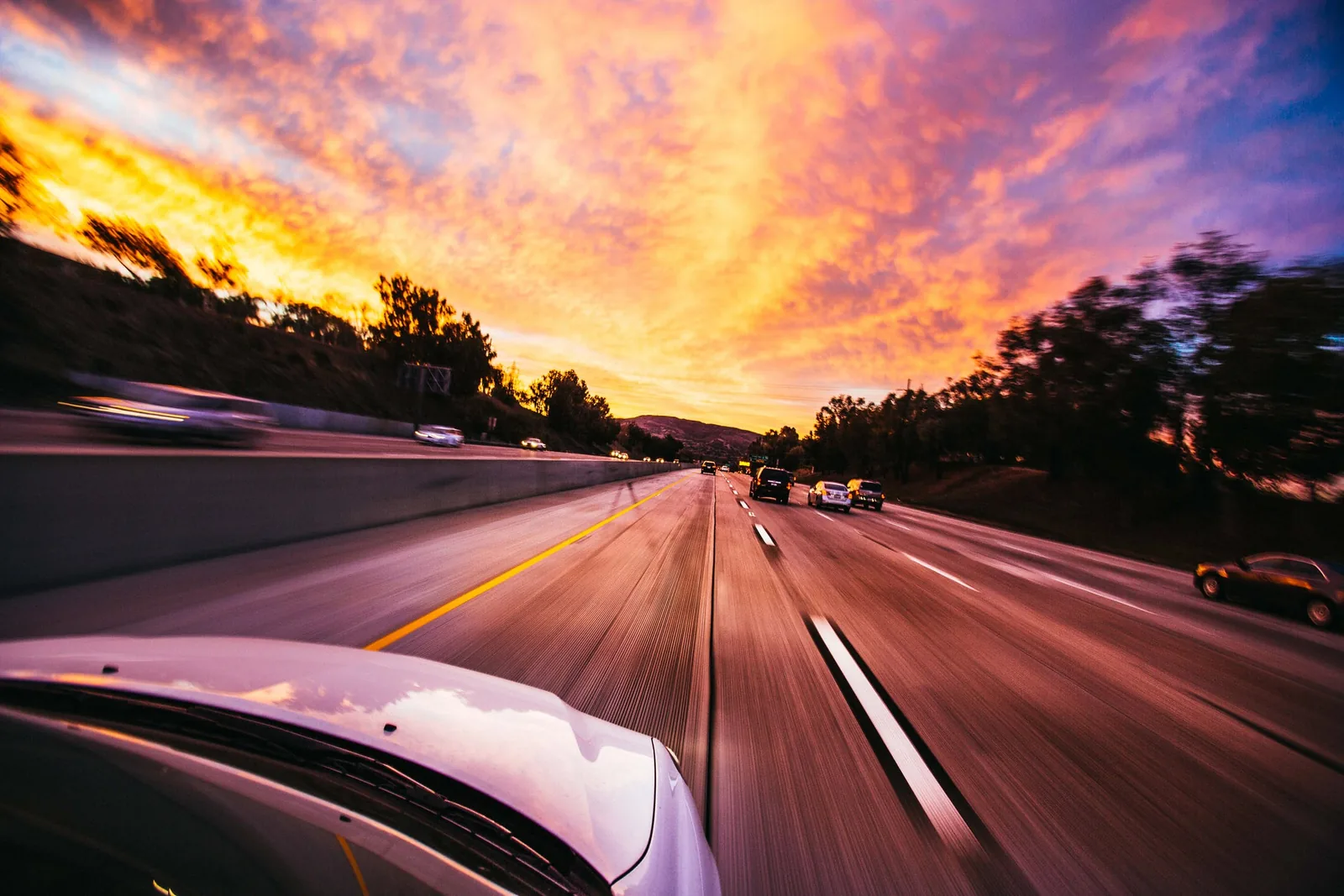 A road and traffic photographed at sunset