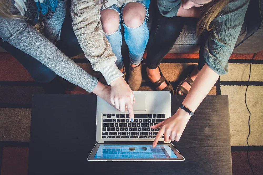 People gathered around a laptop at a table