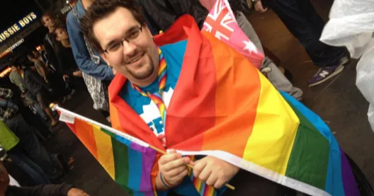 A person holding a rainbow flag at a public gathering