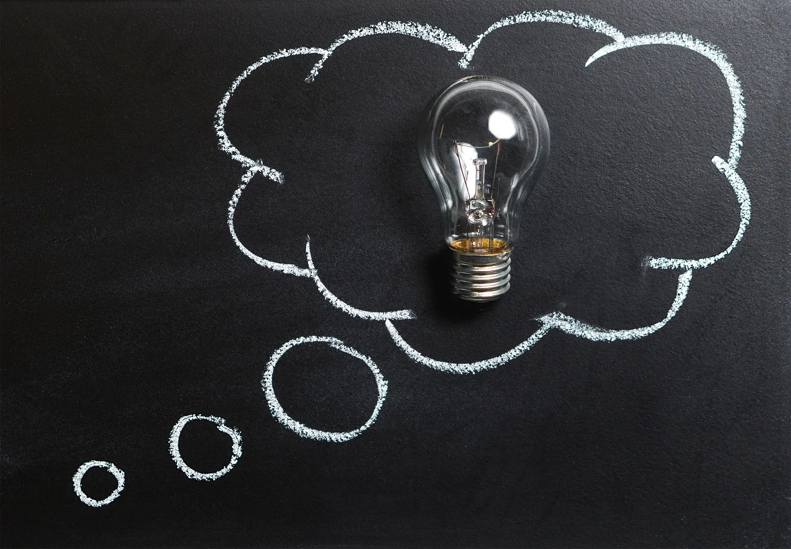 A light bulb inside a chalk-drawn thought bubble
