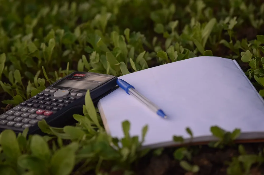 A notebook, pen and calculator outdoors