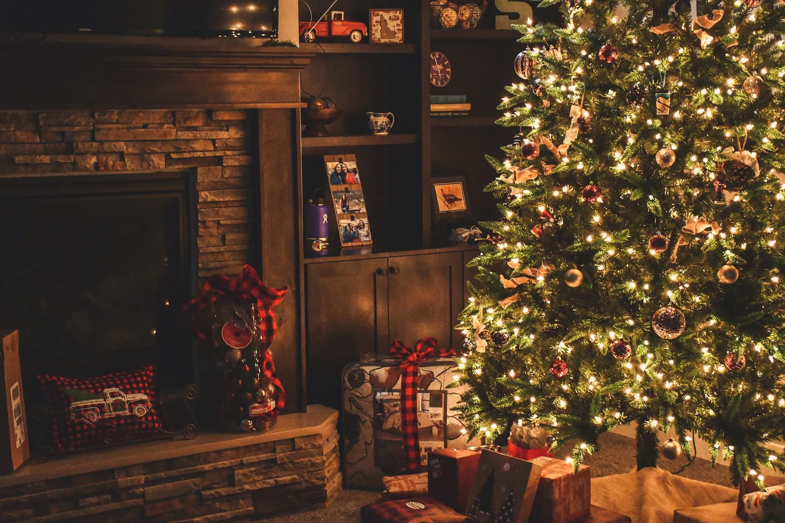 A decorated Christmas tree beside a fireplace