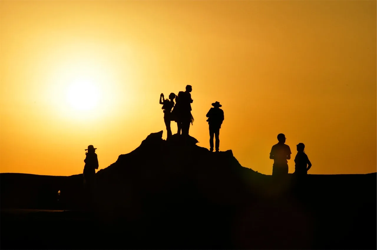 Silhouettes of people on a hill in warm evening light