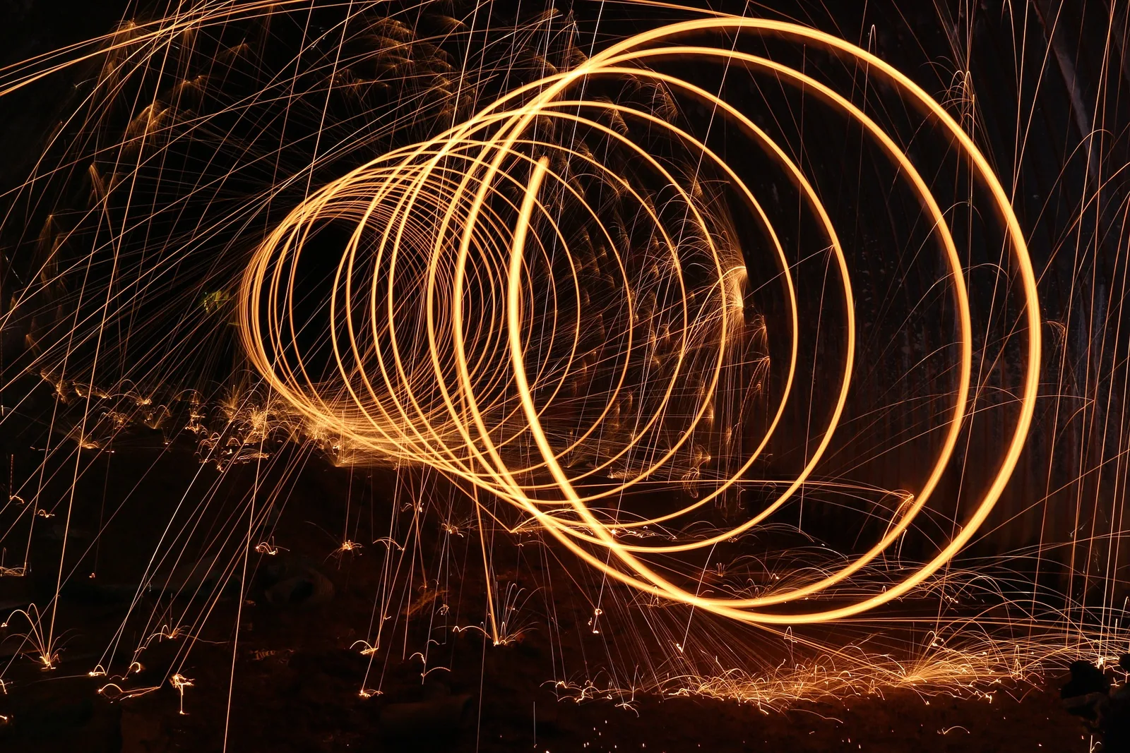 Bright circular trails of light against a dark background