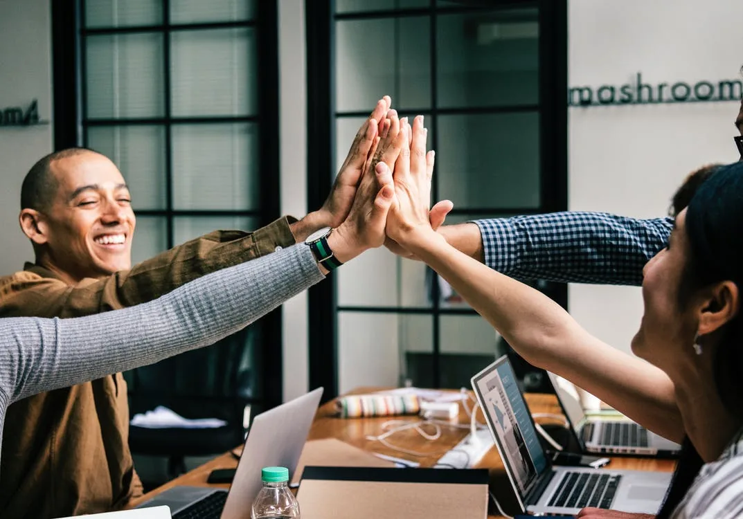People sharing a high five across a table